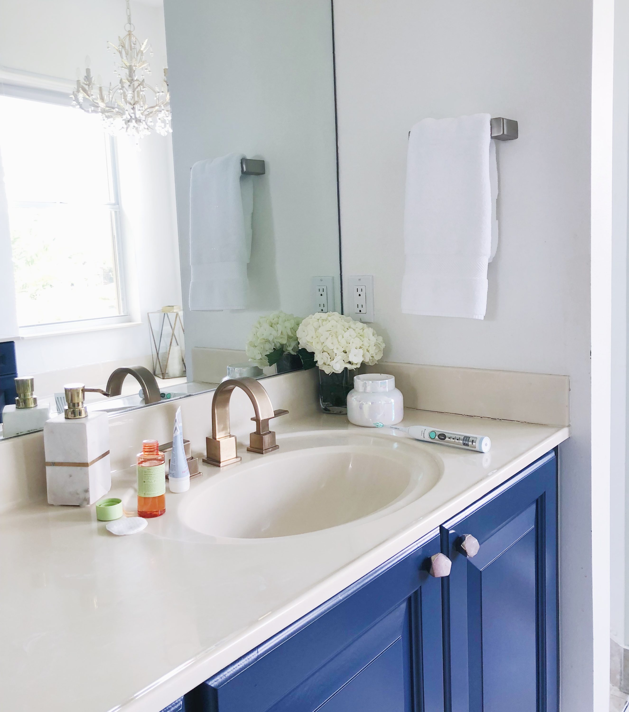 Master Bathroom with DIY blue cabinets and gold hardware | Avon | My Nighttime Routine featured by popular Florida life and style blogger The Modern Savvy