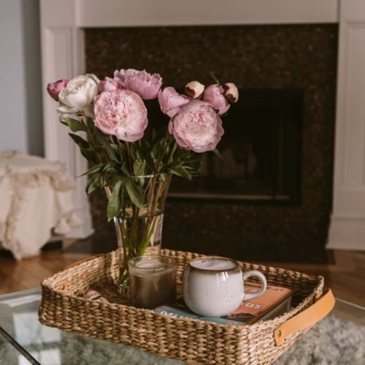 Favorite Weekend Sale by popular Florida life and style blog, The Modern Savvy: image of a vase of peonies in a wicker nesting basket on a glass coffee table.