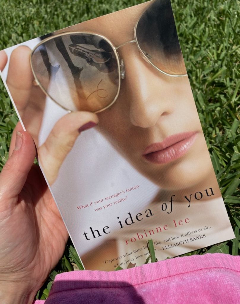 How to Feel Happy Again by popular Florida lifestyle blog, The Modern Savvy: image of a woman holding the book The Idea of You.