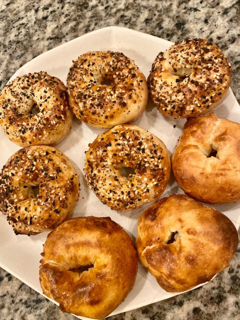 Bagel Recipe by popular Florida lifestyle blog, The Modern Savvy: image of some bagels on a white ceramic plate. 